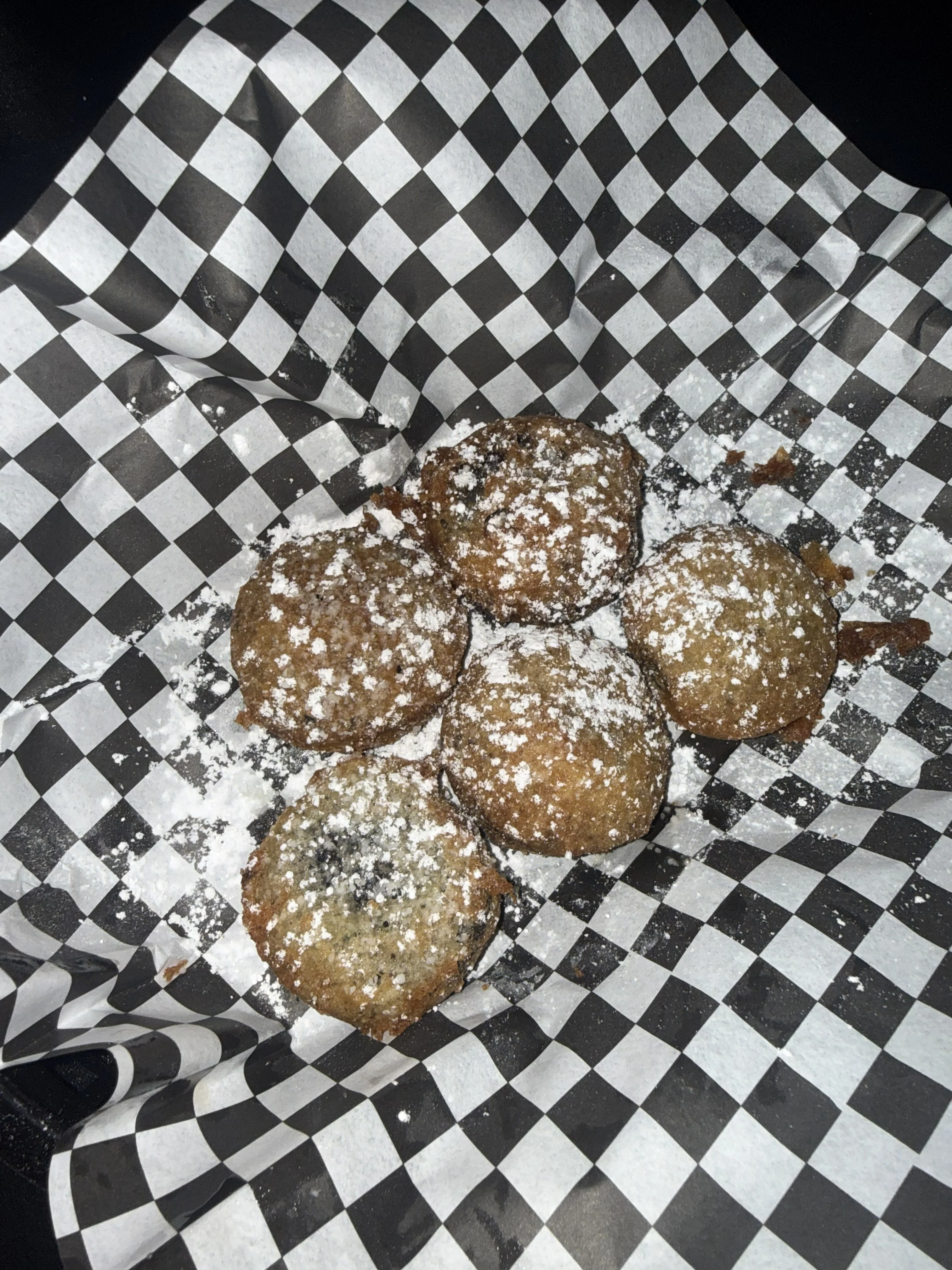 Fried falafel served on black and white checkered paper