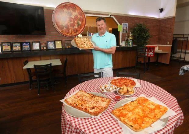 Variety of pizzas including pepperoni and cheese in a cozy restaurant setting