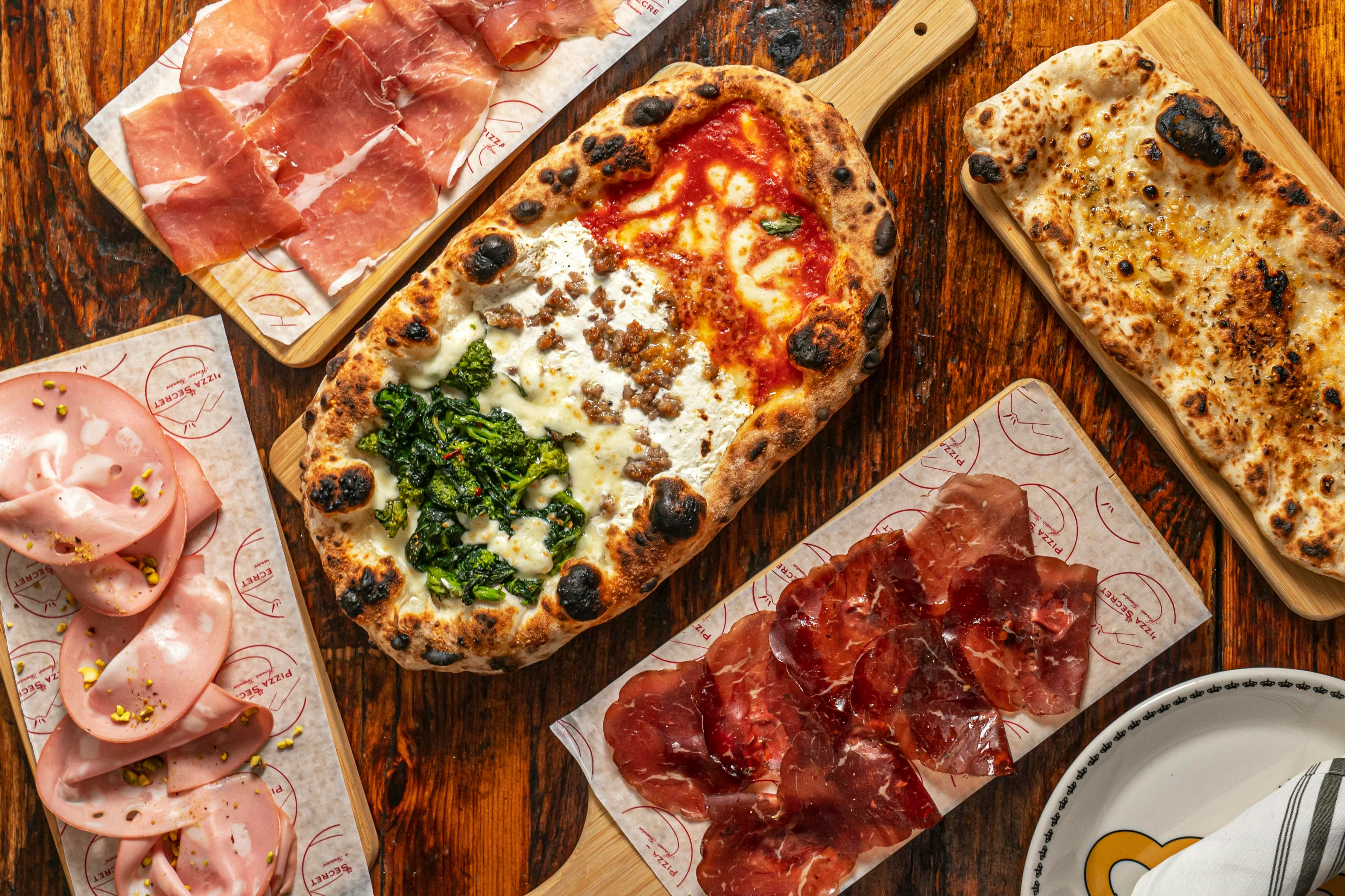 Italian pizza with sausage and greens on a wooden table