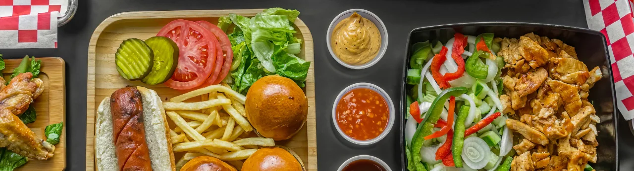 American fast food spread with burgers, wings, and hot dogs