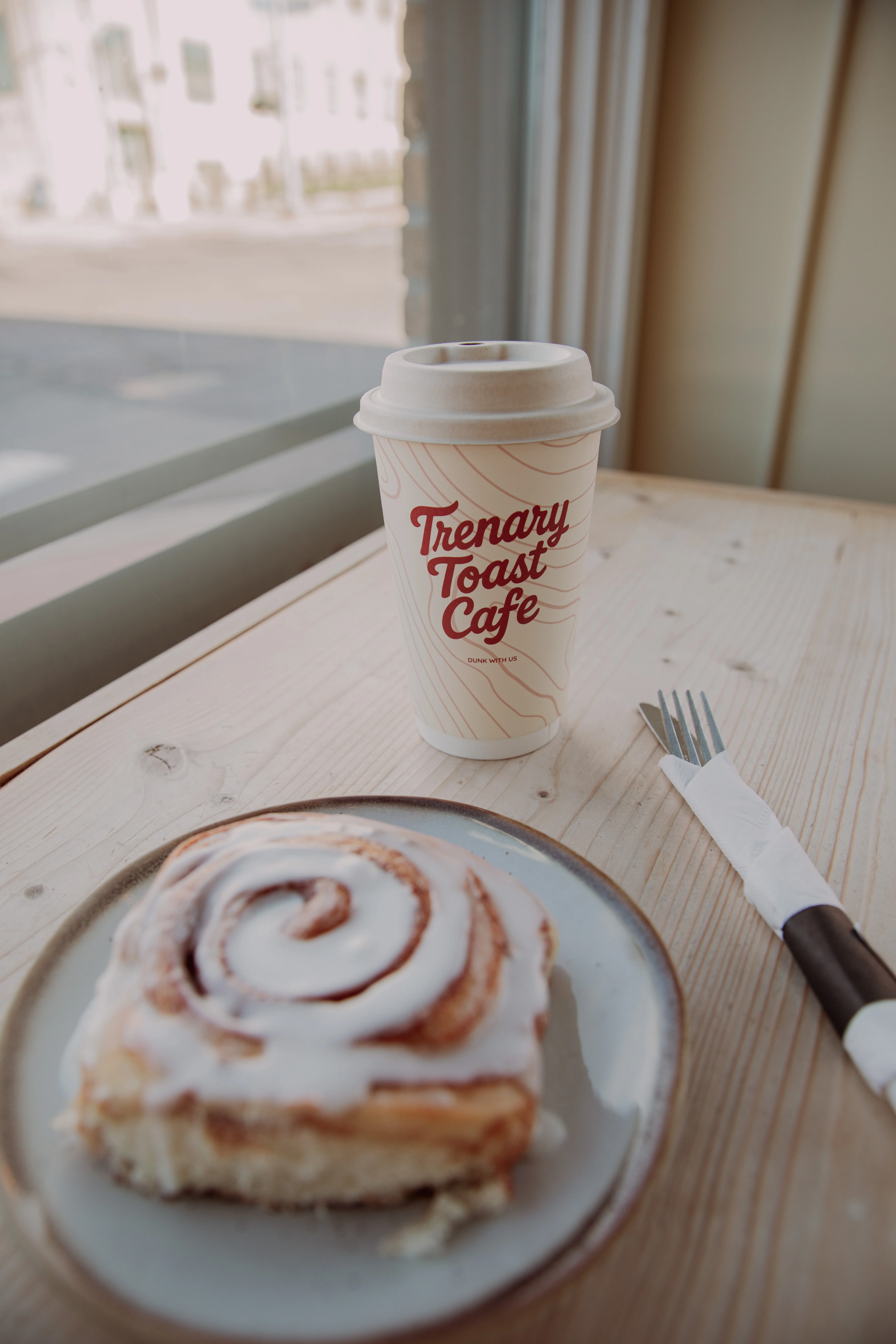 Cinnamon roll with icing at a cozy café
