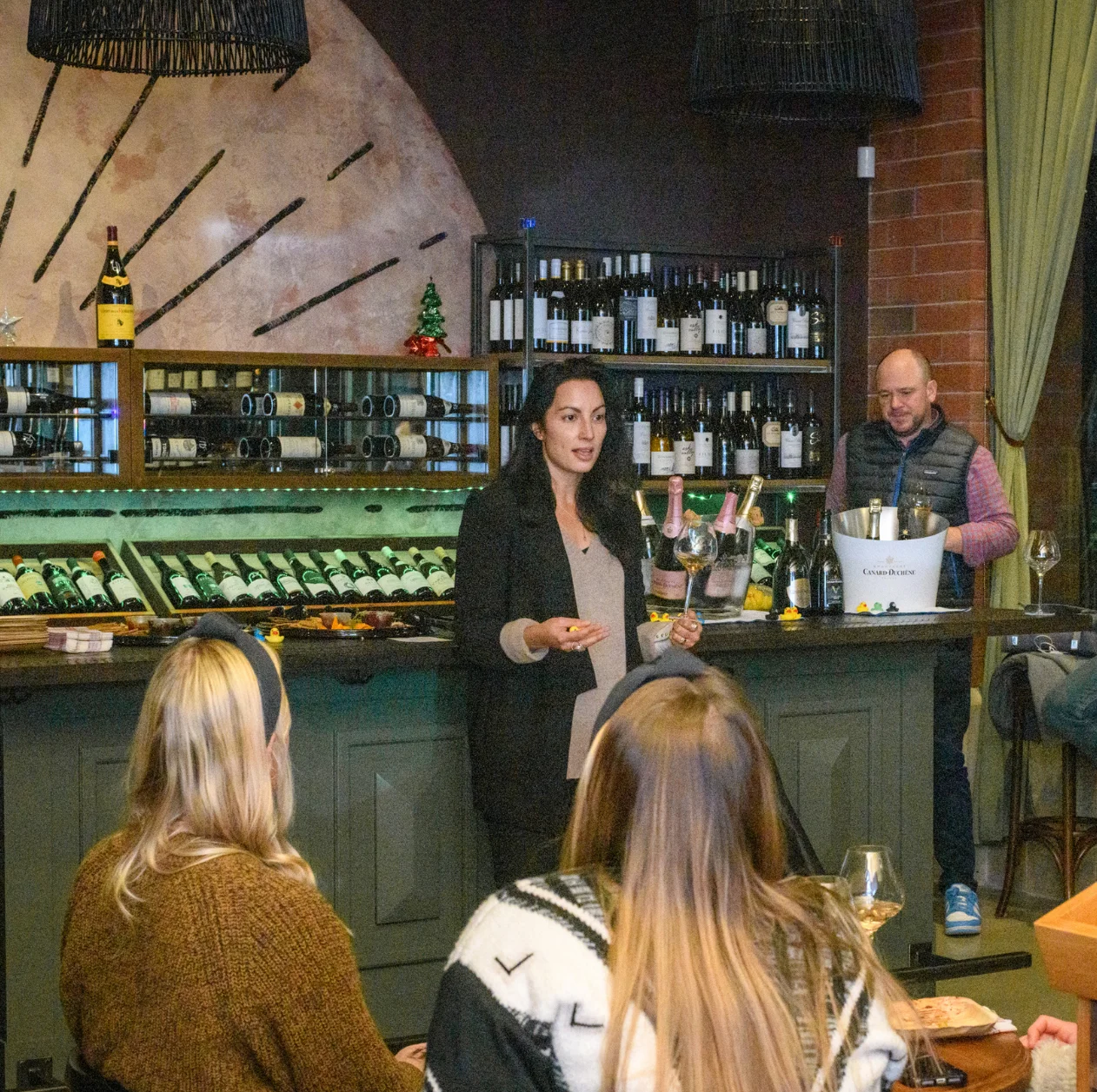 Wine tasting event with guests enjoying a presentation at a stylish bar