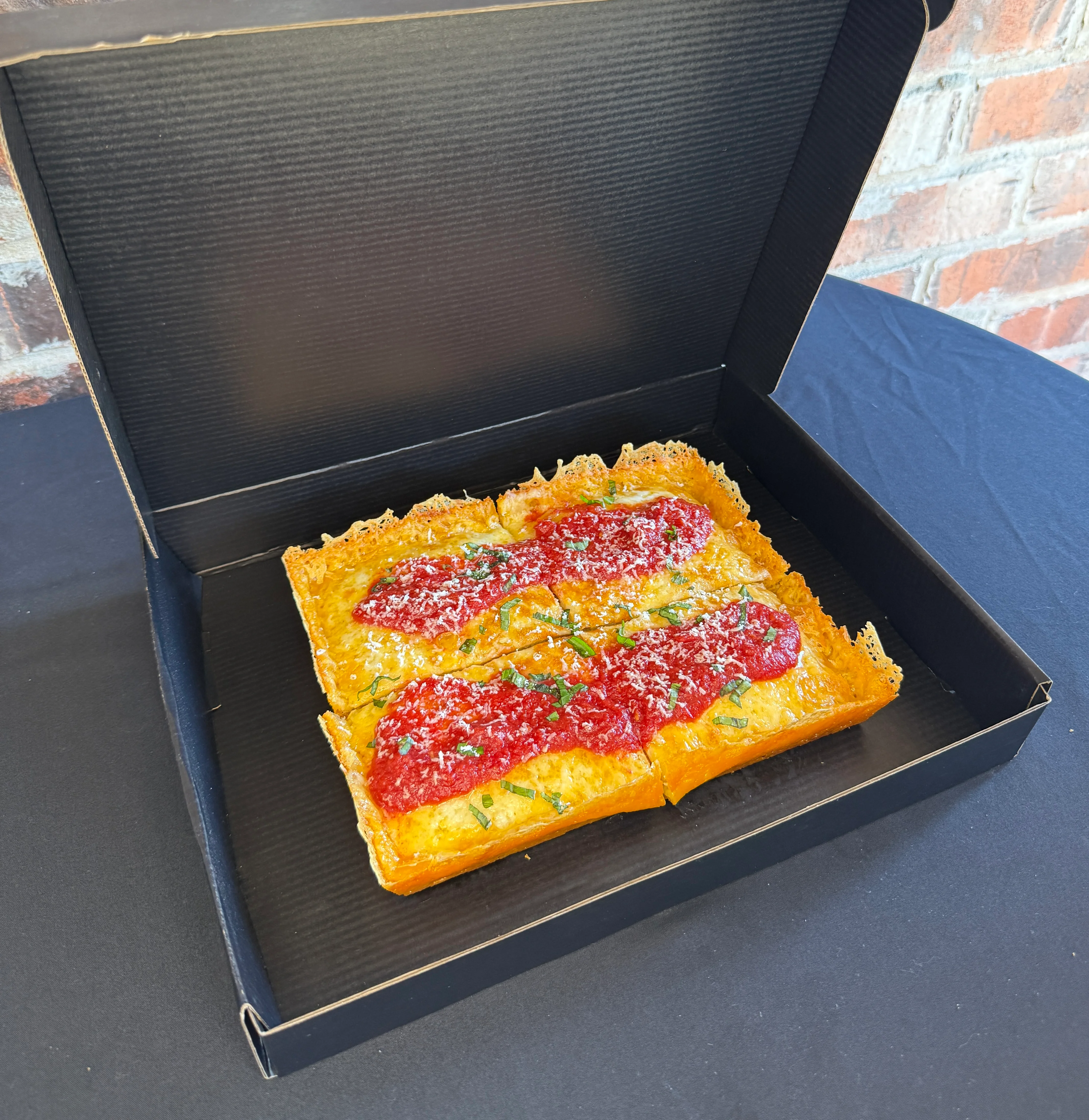 Detroit-style pizza with marinara sauce and cheese