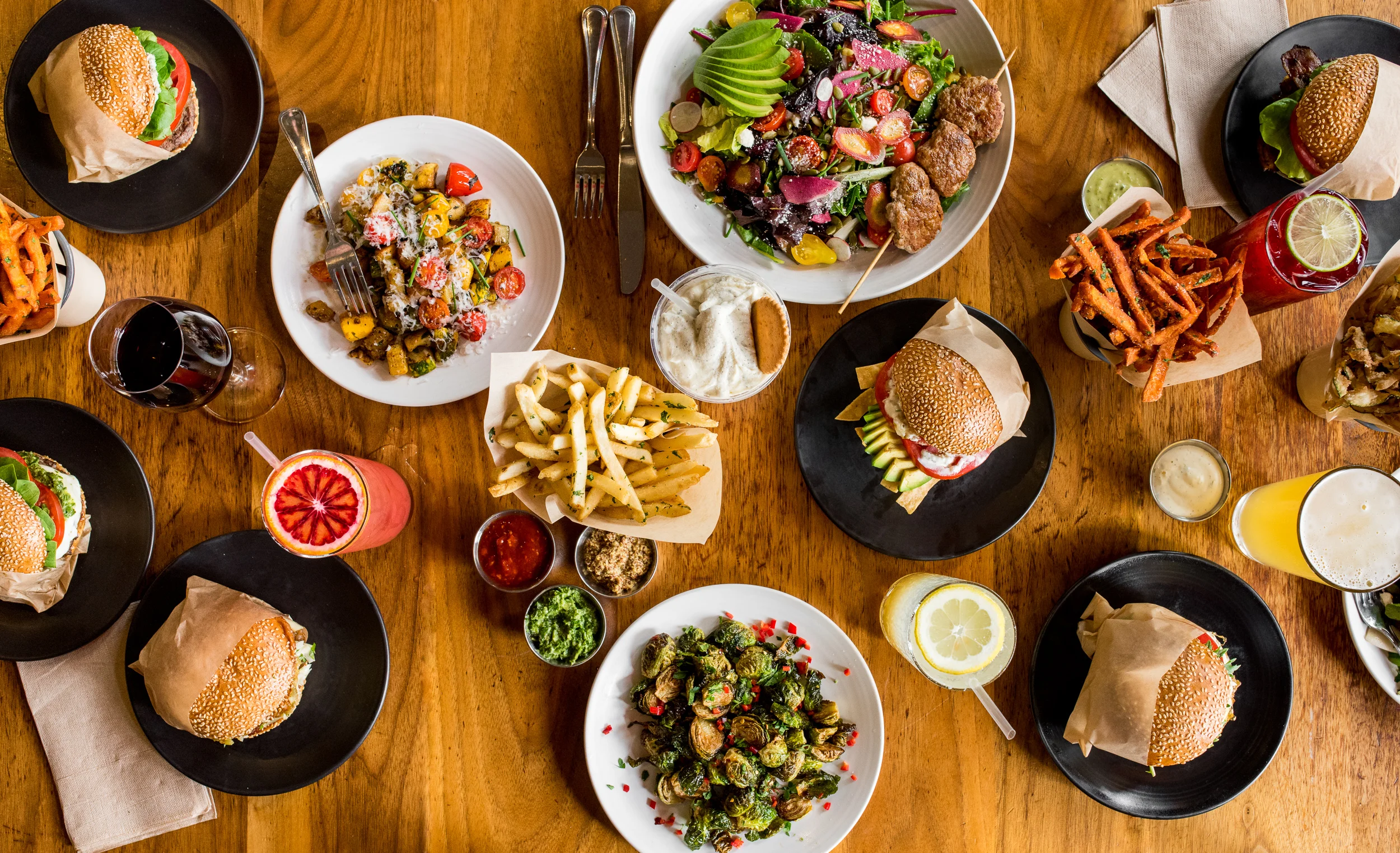 Assorted gourmet burgers and salads in a vibrant restaurant setting