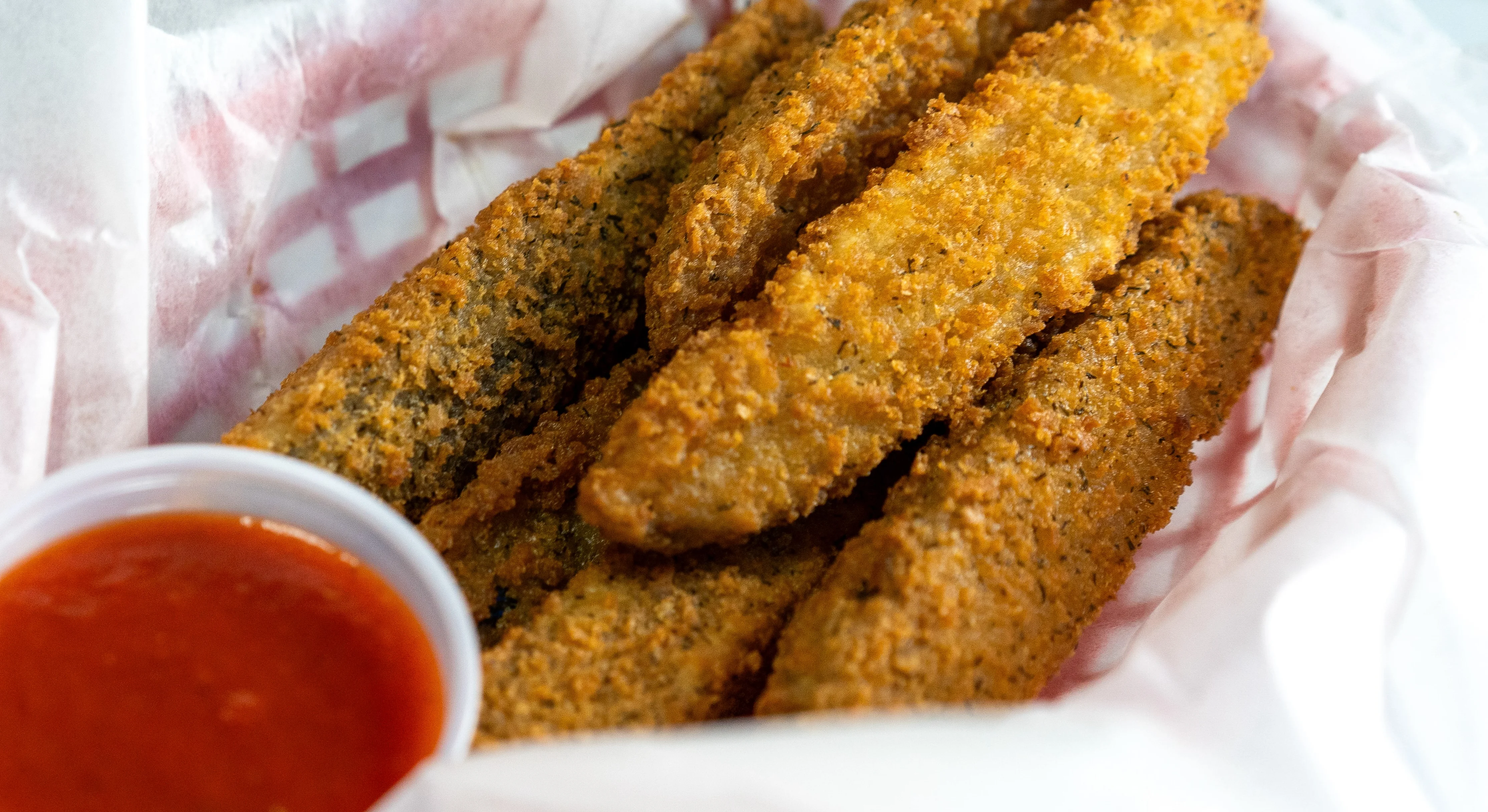 Breaded pickles in paper-lined basket.
