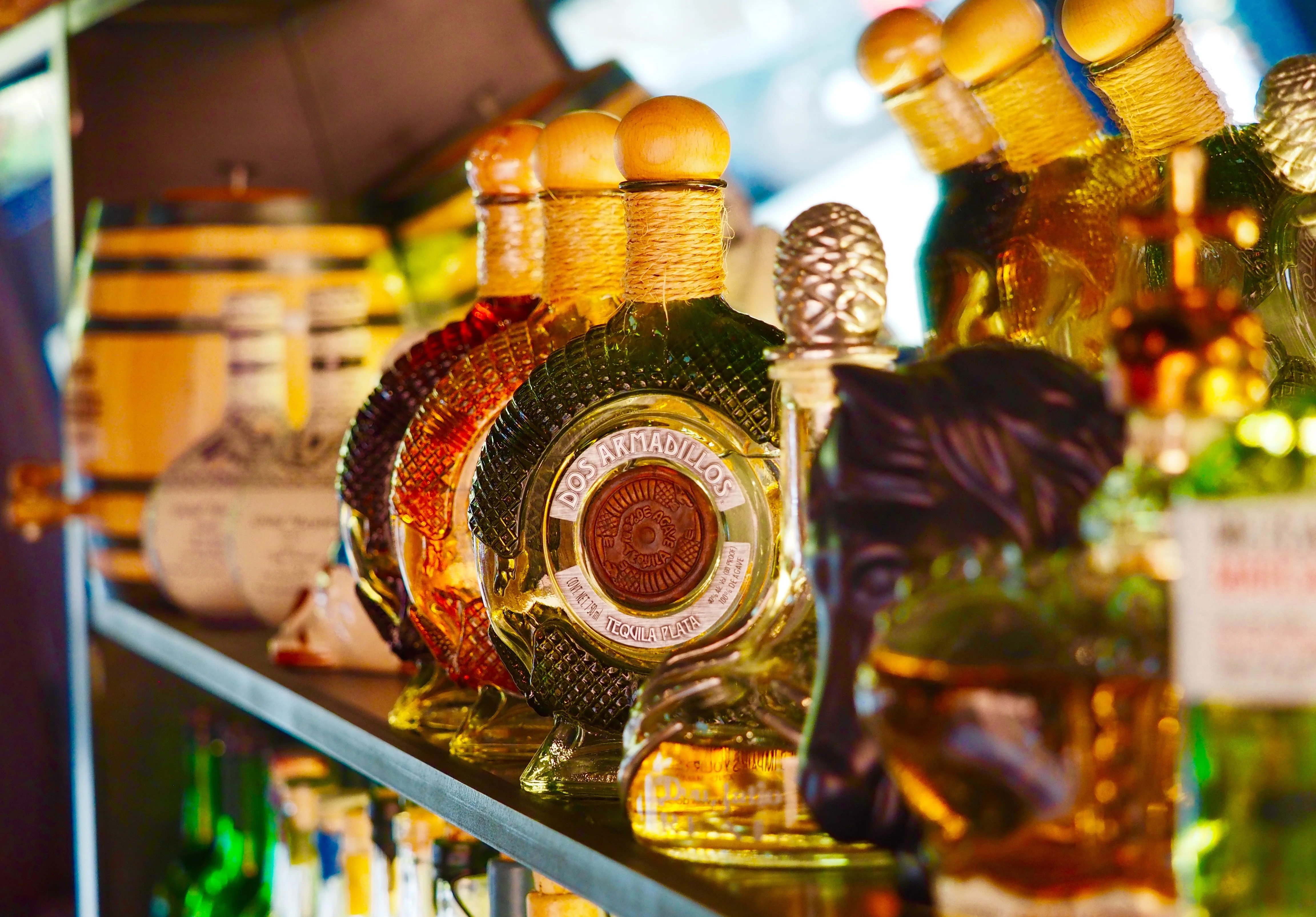 Colorful tequila bottles displayed on a bar shelf