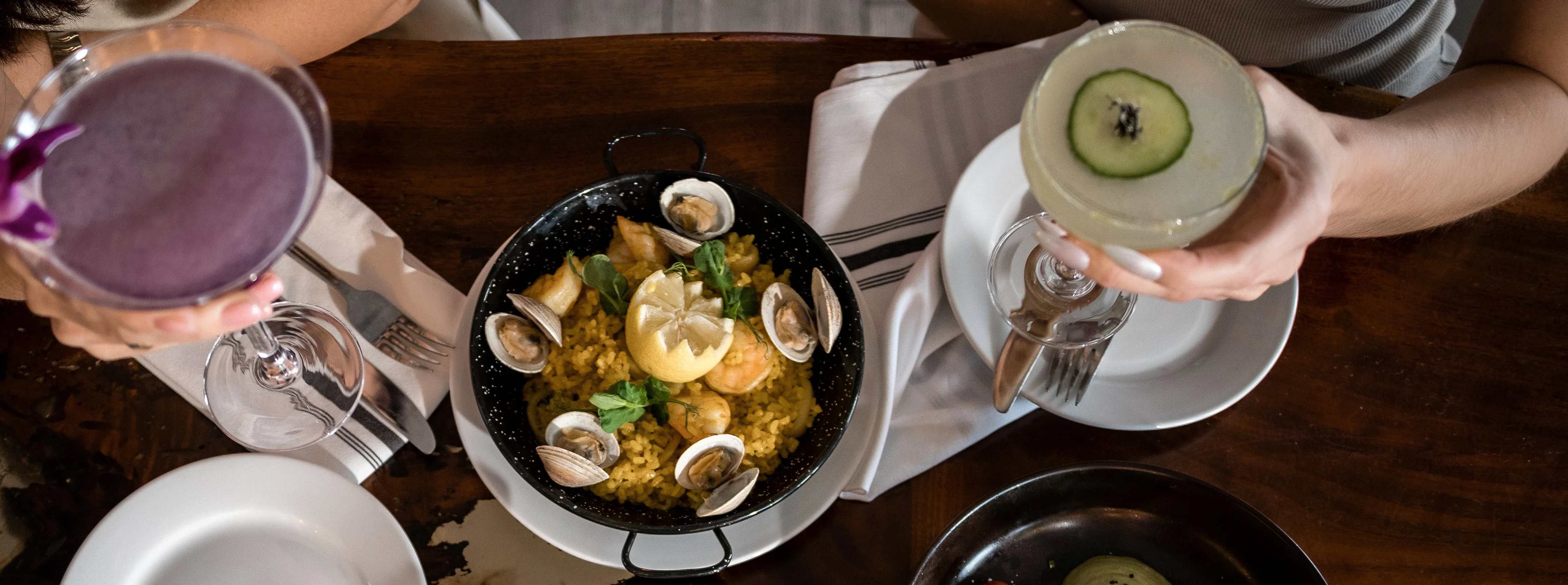 Colorful paella with seafood and cocktails in a vibrant dining setting