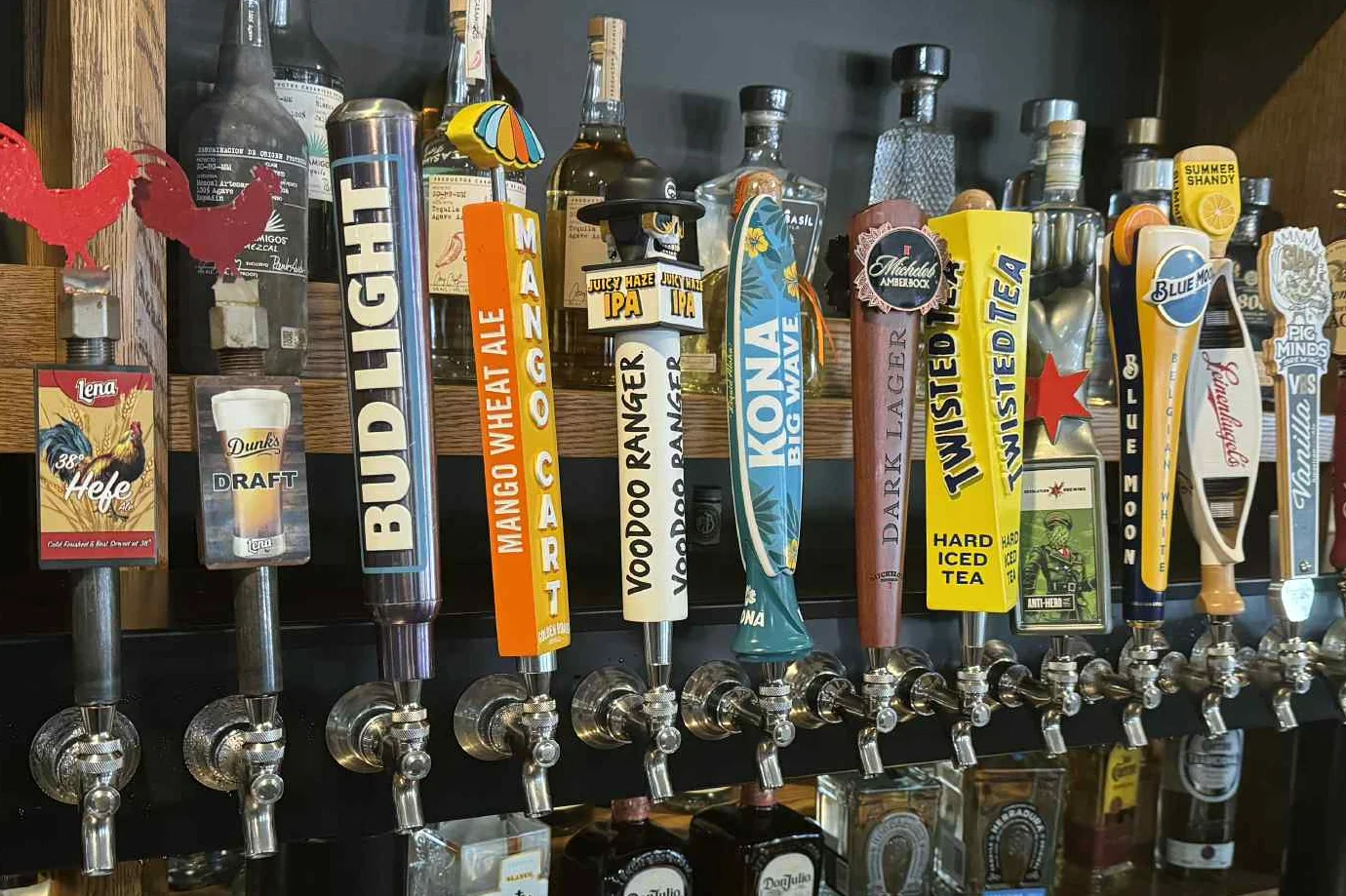 A plate of tacos served with a large margarita, a Bud Light beer, and a bottle of Patrón tequila at the bar, with colorful slot machines in the background.