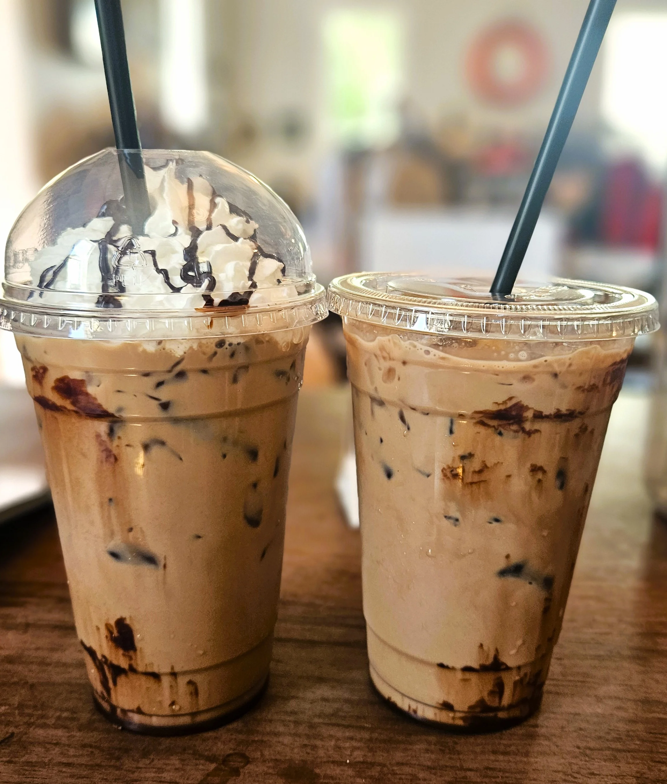 Iced coffee drinks topped with whipped cream and chocolate drizzle