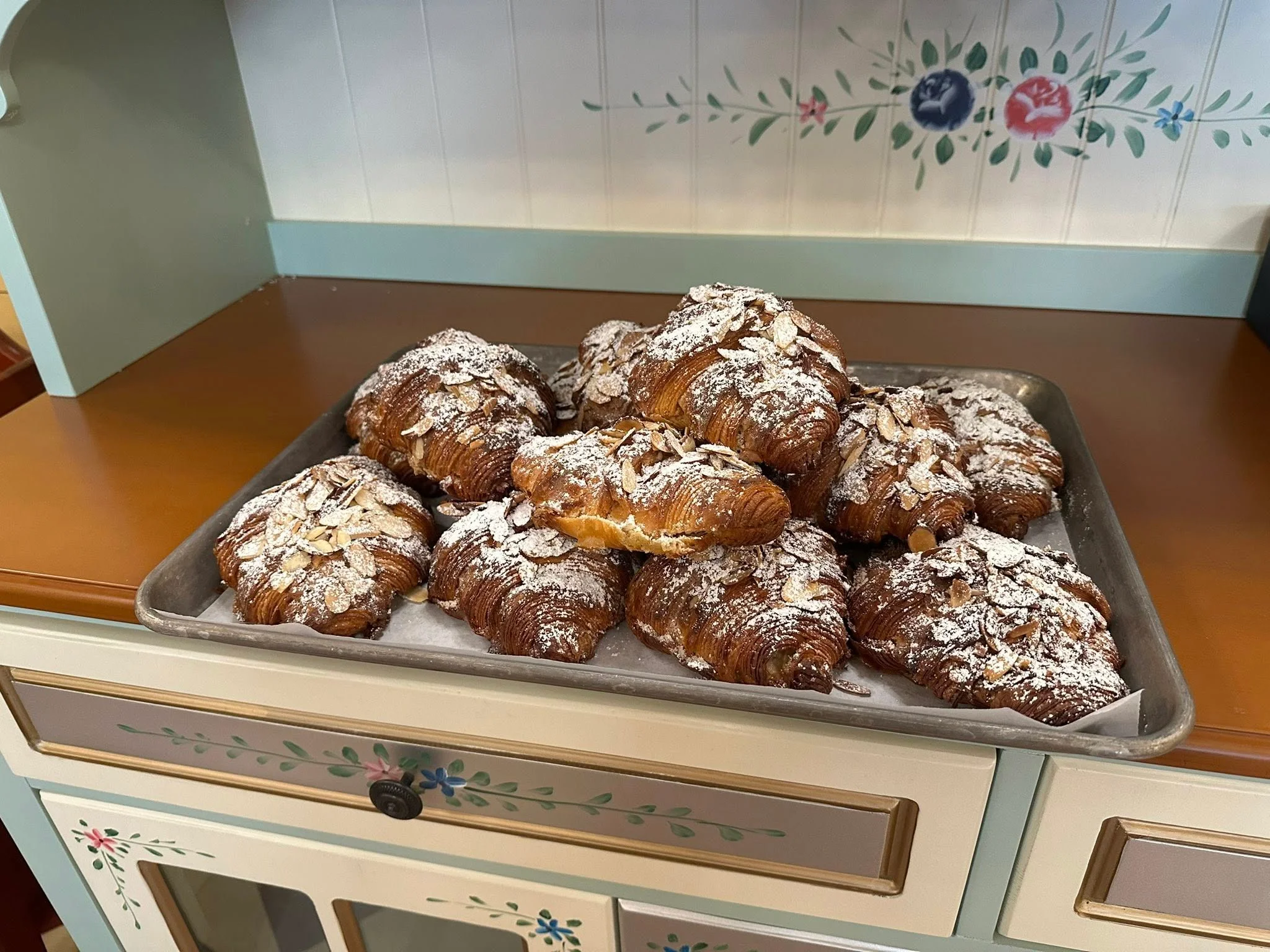 Freshly baked almond croissants dusted with powdered sugar