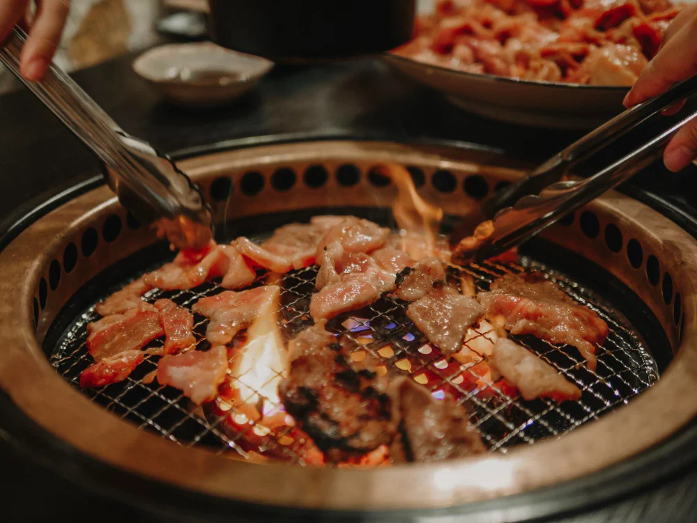 Korean barbecue with marinated meats grilling over charcoal