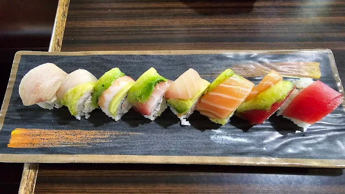 Assorted sushi rolls on a black plate