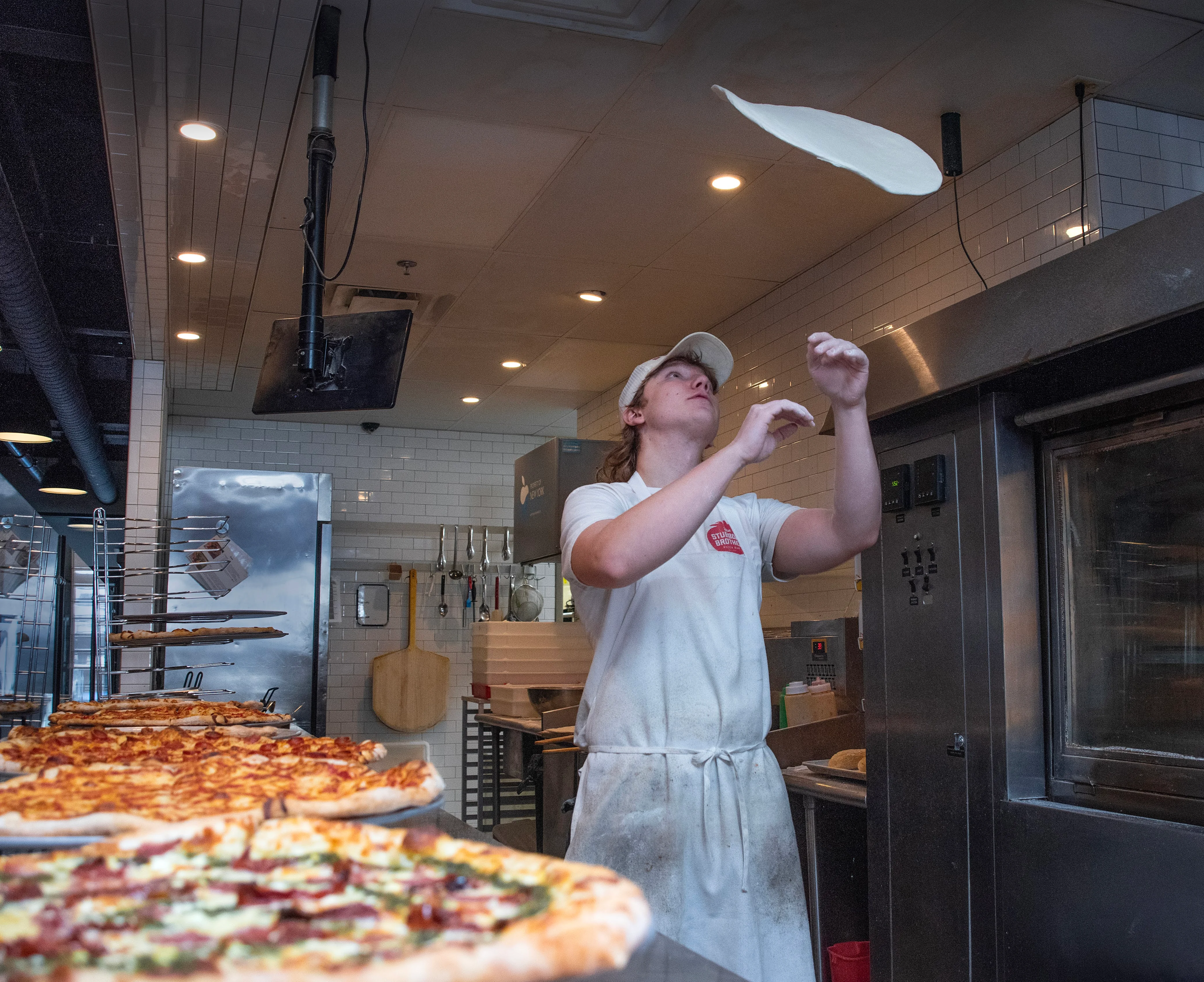Pizza chef tossing dough in a modern pizzeria