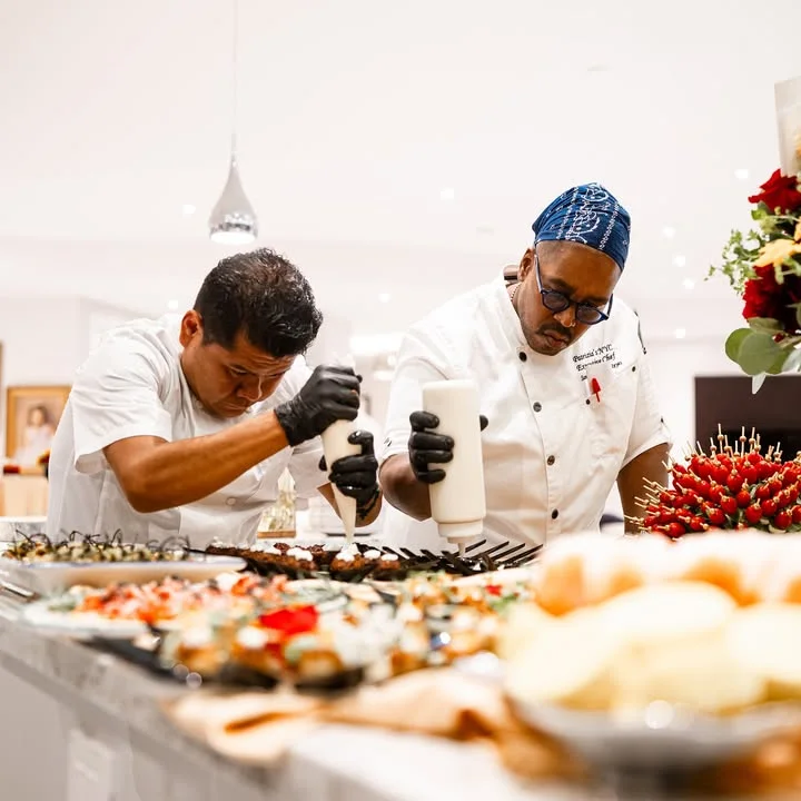 Chefs preparing sushi rolls in a modern kitchen