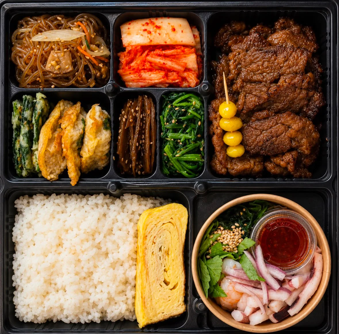 Korean bento box with assorted side dishes and grilled beef