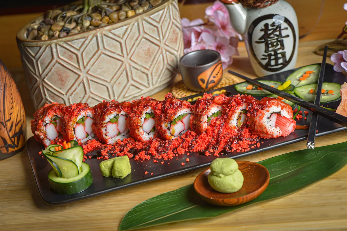 Colorful sushi rolls with spicy toppings on a black plate