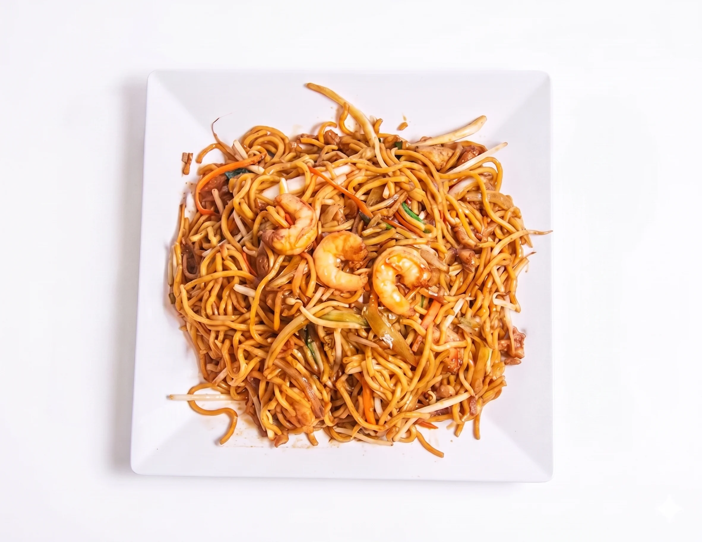 Plate of shrimp chow mein with vegetables and noodles.