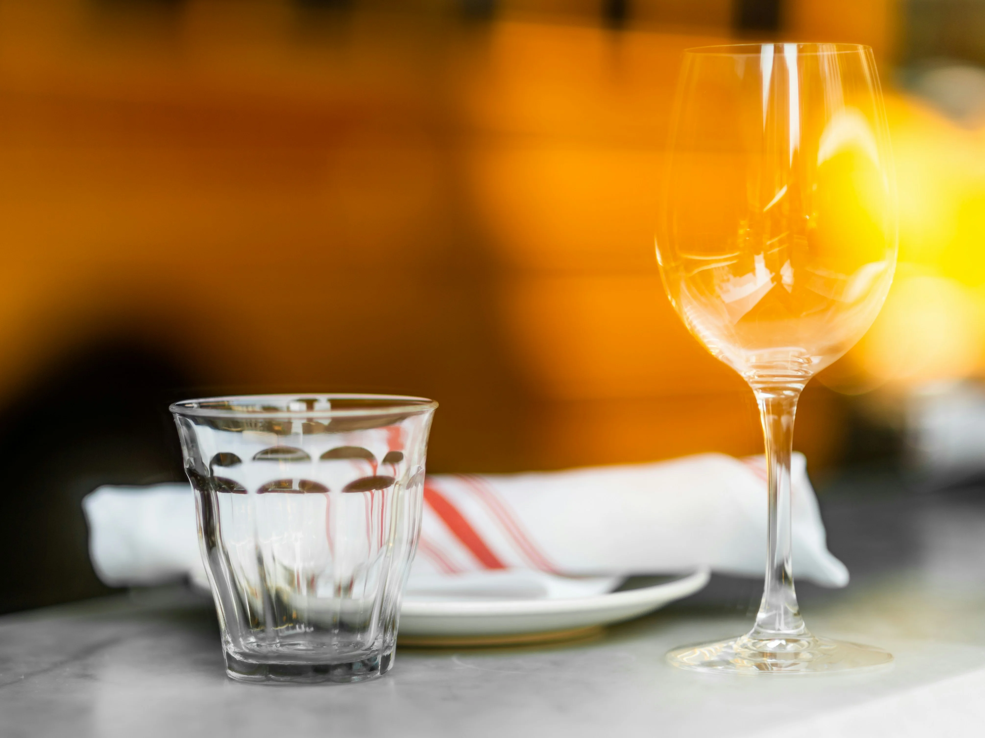 An empty cup and glass on a table, ready for service.