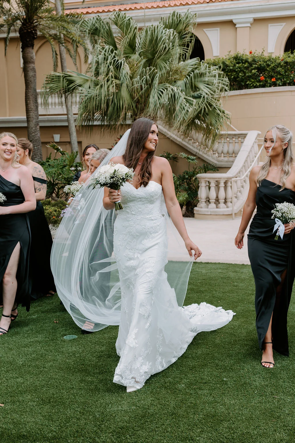 Bride walking with bridesmaids in elegant outdoor setting