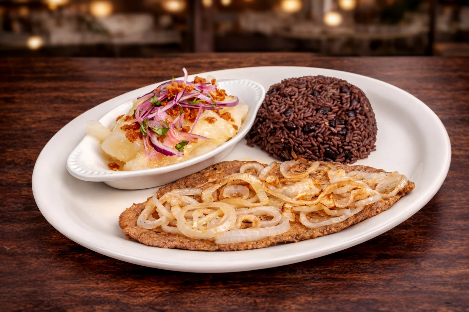Fried fish with onions and black rice, a traditional Latin American dish