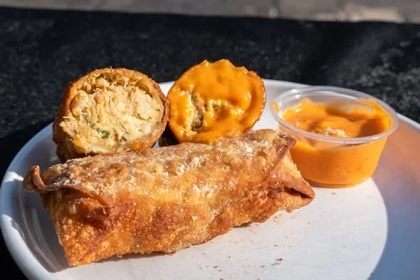 Crispy fried empanada platter with savory croquettes and cheese sauce