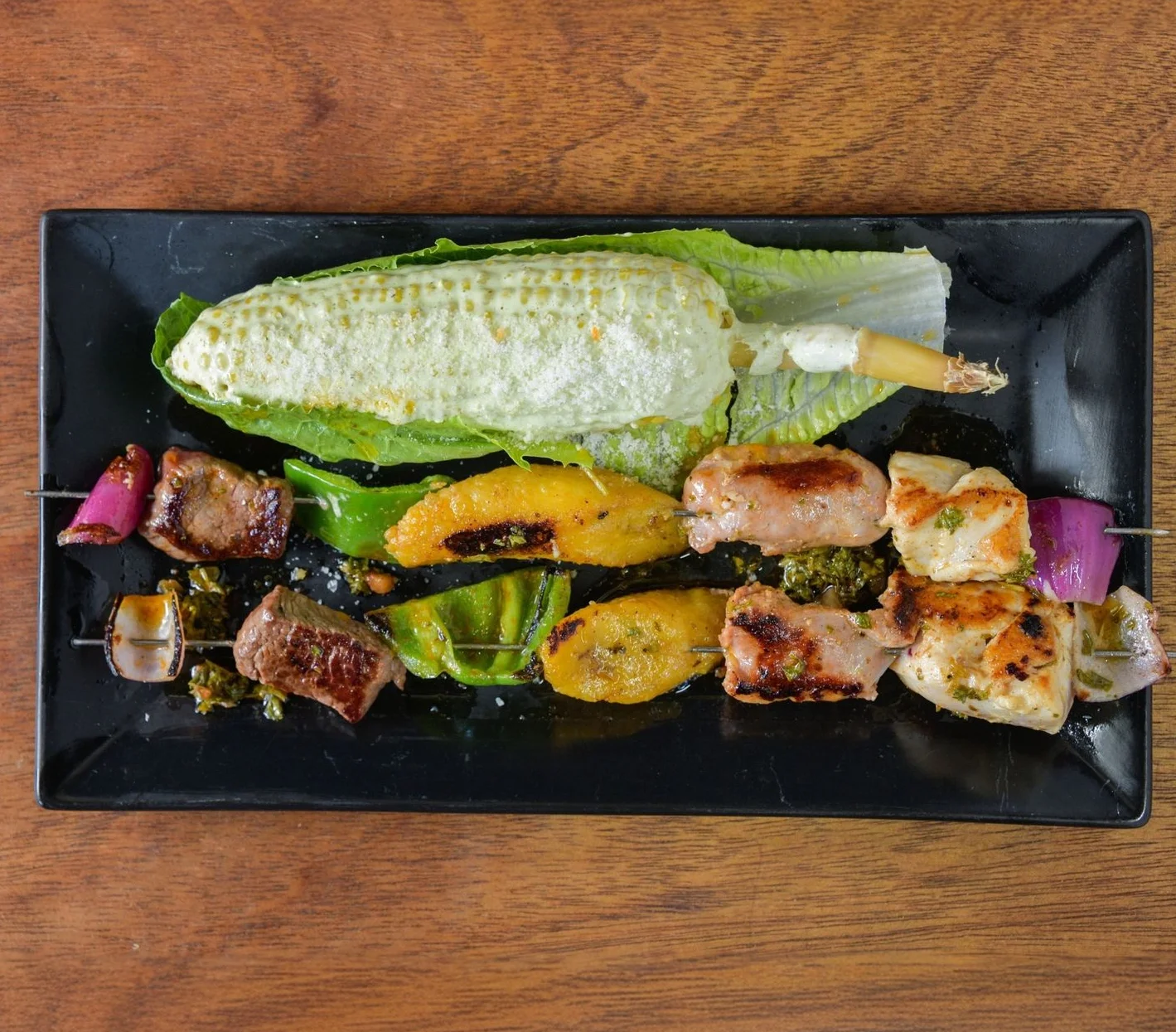 A platter of mixed skewers featuring grilled meats and vegetables.