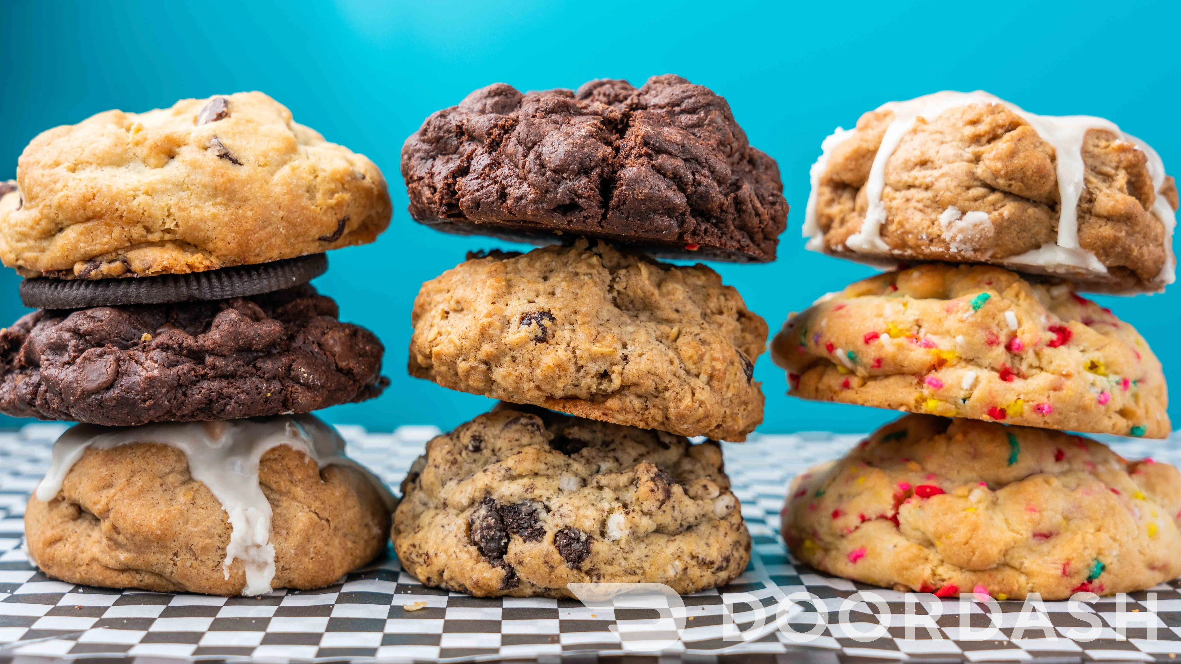 Assorted gourmet cookies stacked on a checkered tray