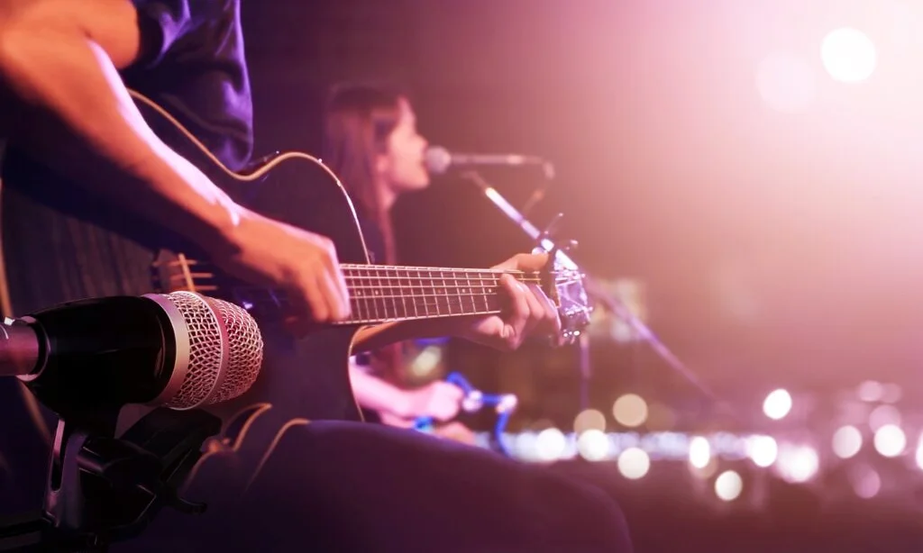Live music performance with acoustic guitar and microphone