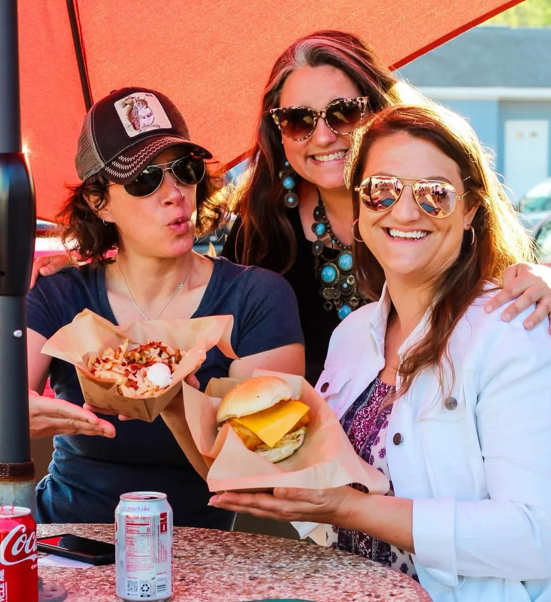 Friends enjoying loaded fries and a cheeseburger at a casual eatery