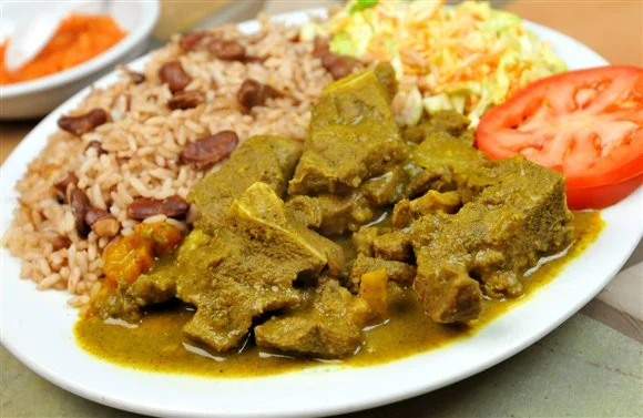 Jamaican curry goat served with rice and peas