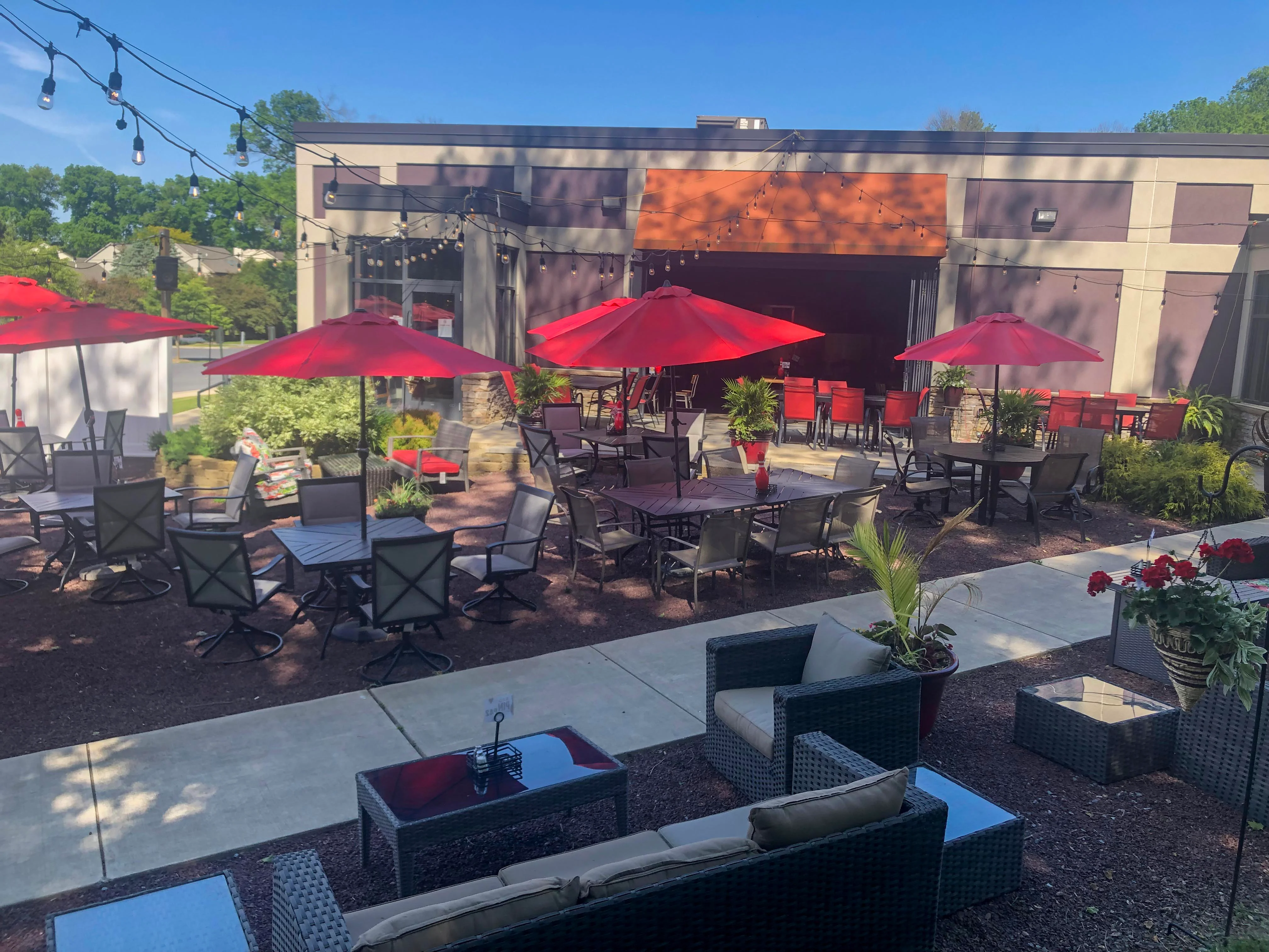 Outdoor dining area with red umbrellas and modern seating