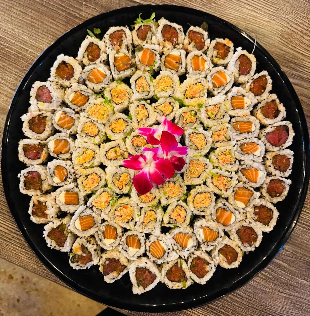Assorted sushi platter with colorful rolls and a flower garnish