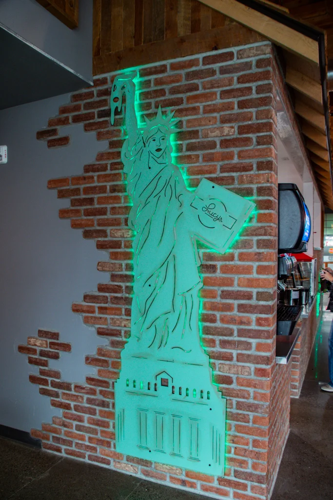 Lady liberty holding a pizza box and slice