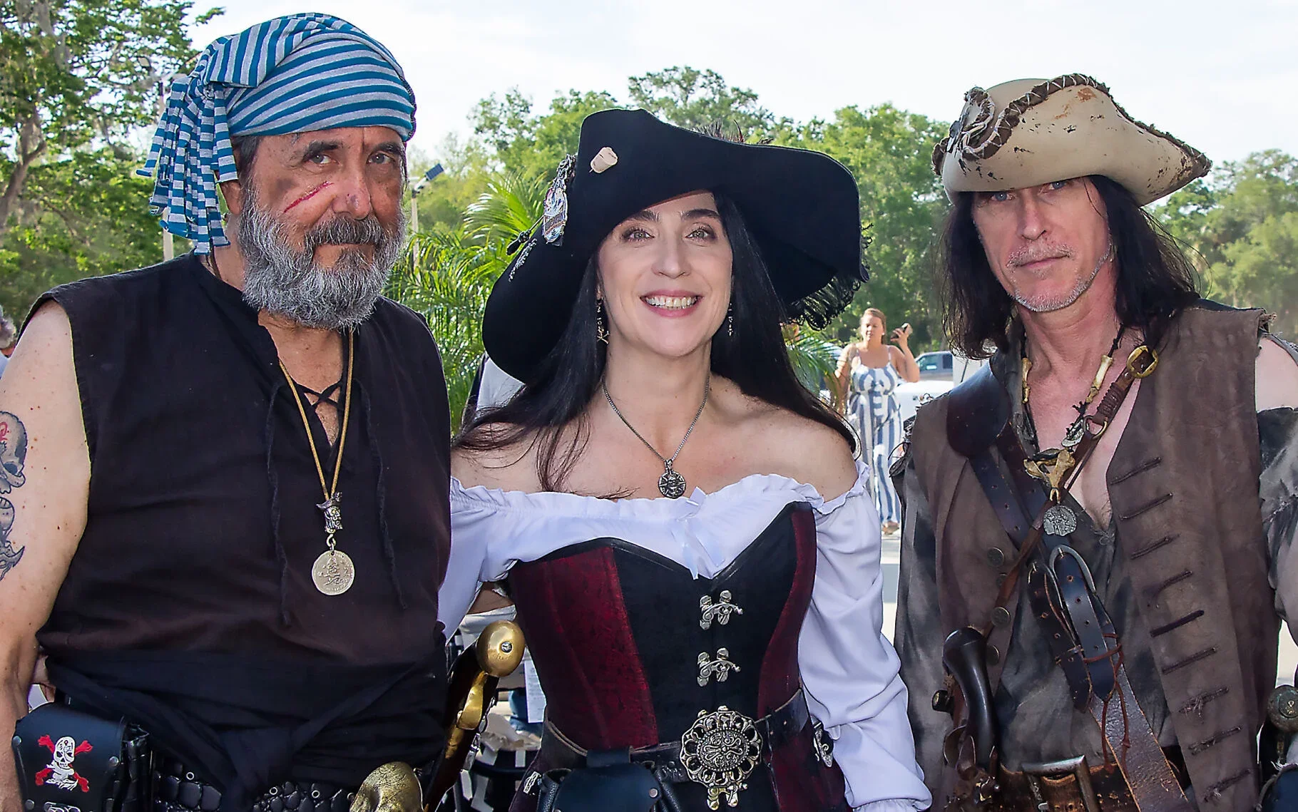 Three individuals in pirate costumes posing for a photo