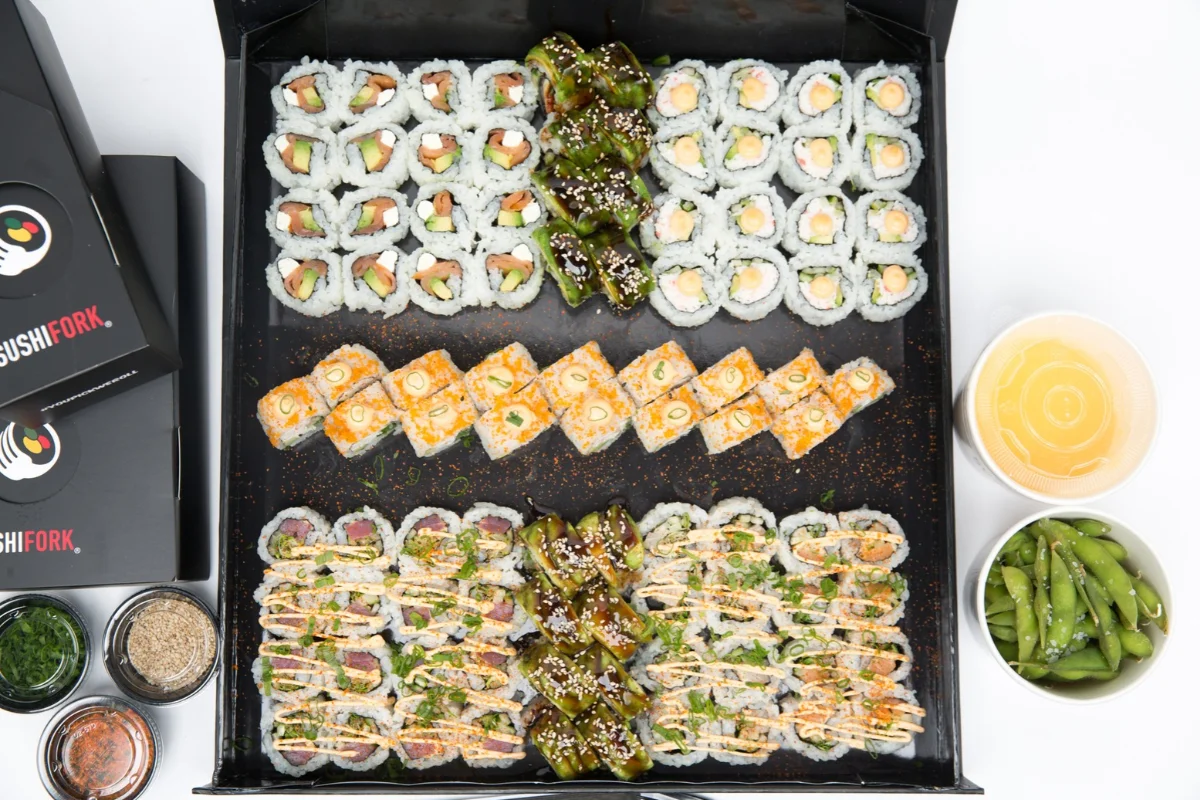 Japanese sushi platter with assorted maki rolls, edamame, and dipping sauces