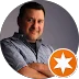 Smiling man posing for a photo with a star badge