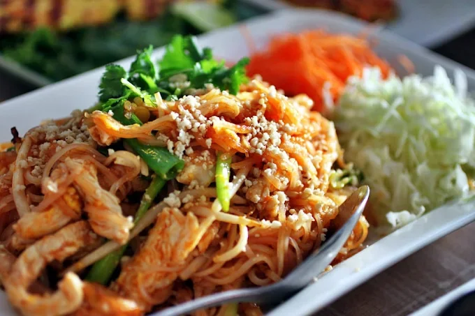 Plate of Thai pad thai with chicken and fresh herbs