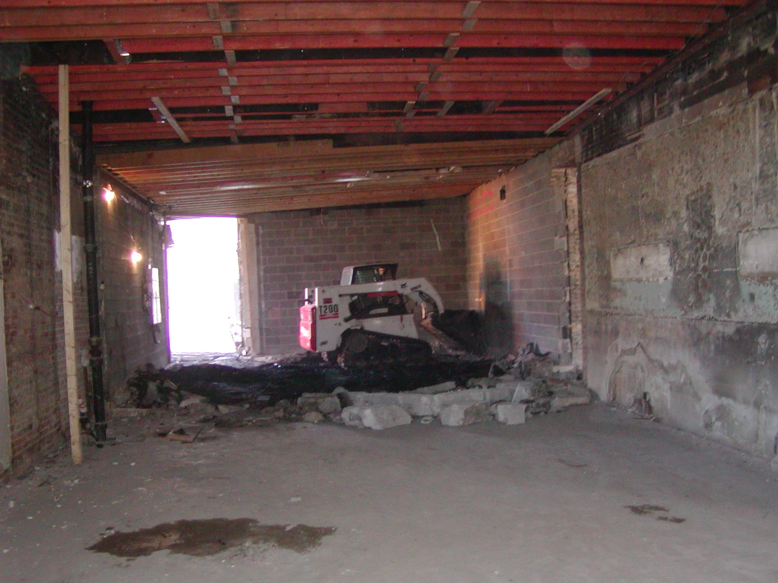 Construction site with machinery and exposed beams in a spacious interior