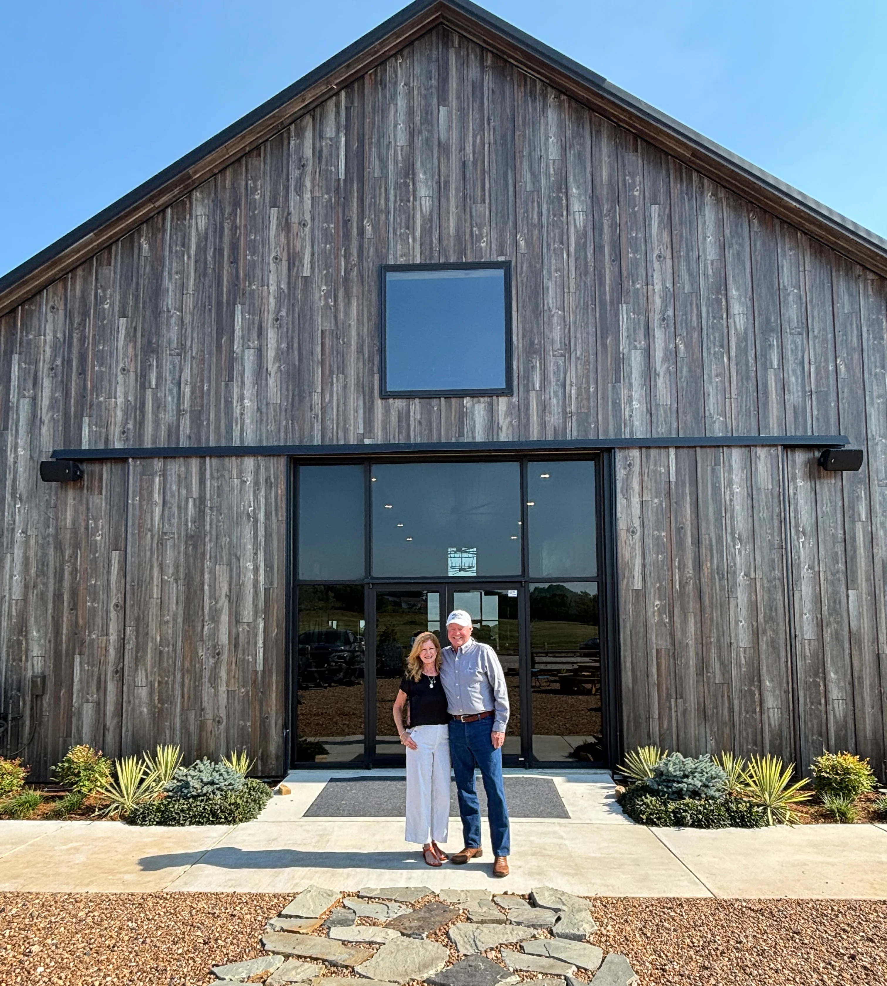 Couple standing in front of a rustic restaurant entrance