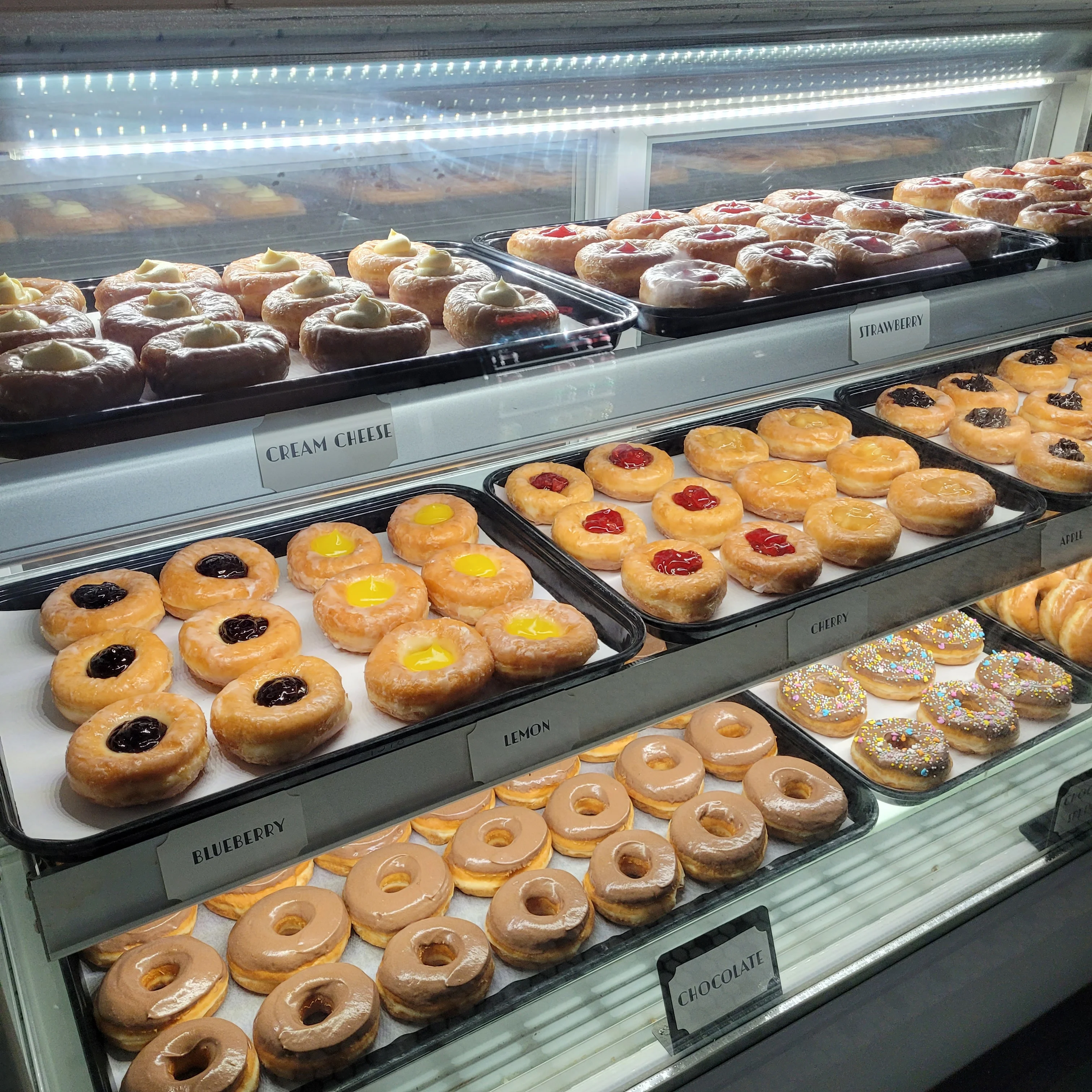 Assorted donuts including cream cheese and fruit-filled varieties
