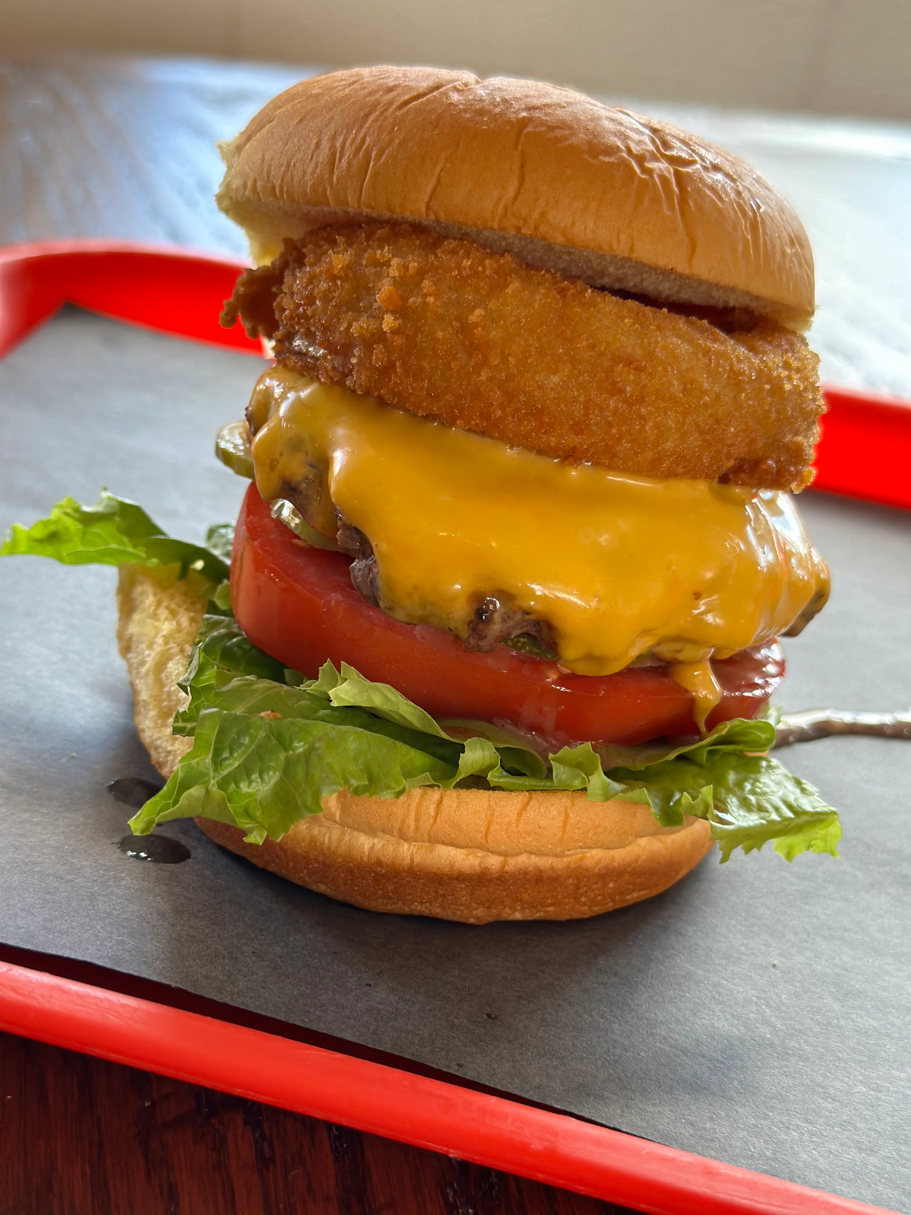 Delicious burger with toppings served on a wooden table