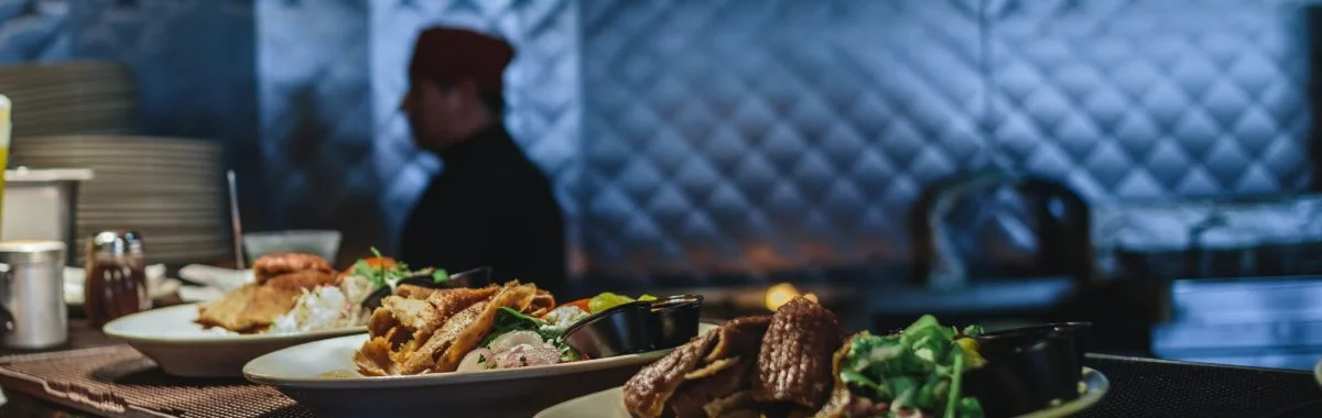 Plates of Mexican tacos with fresh toppings in a restaurant kitchen