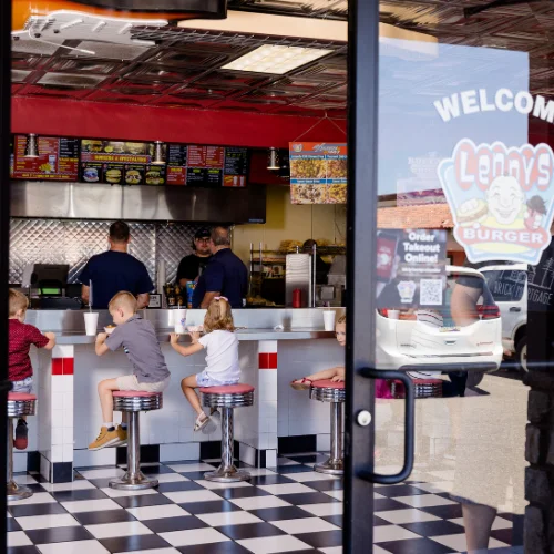 Family-friendly burger restaurant interior with kids at the counter