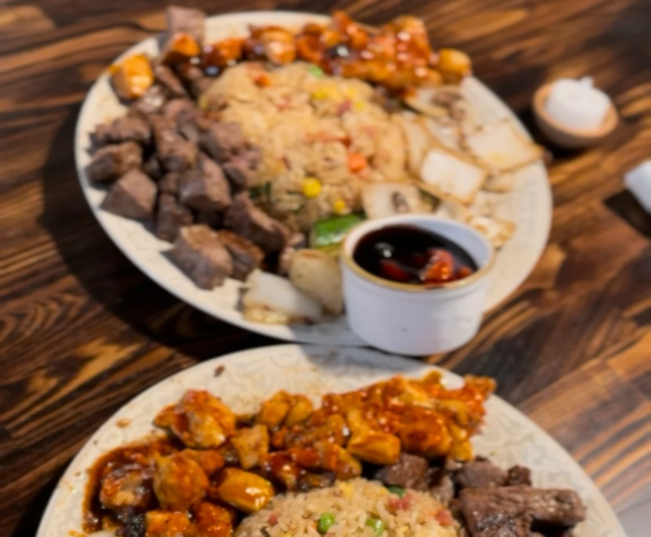 Japanese hibachi platter with fried rice, grilled steak, vegetables, and dipping sauce