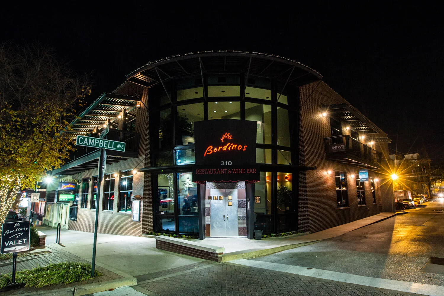 Modern restaurant exterior at night with warm lighting