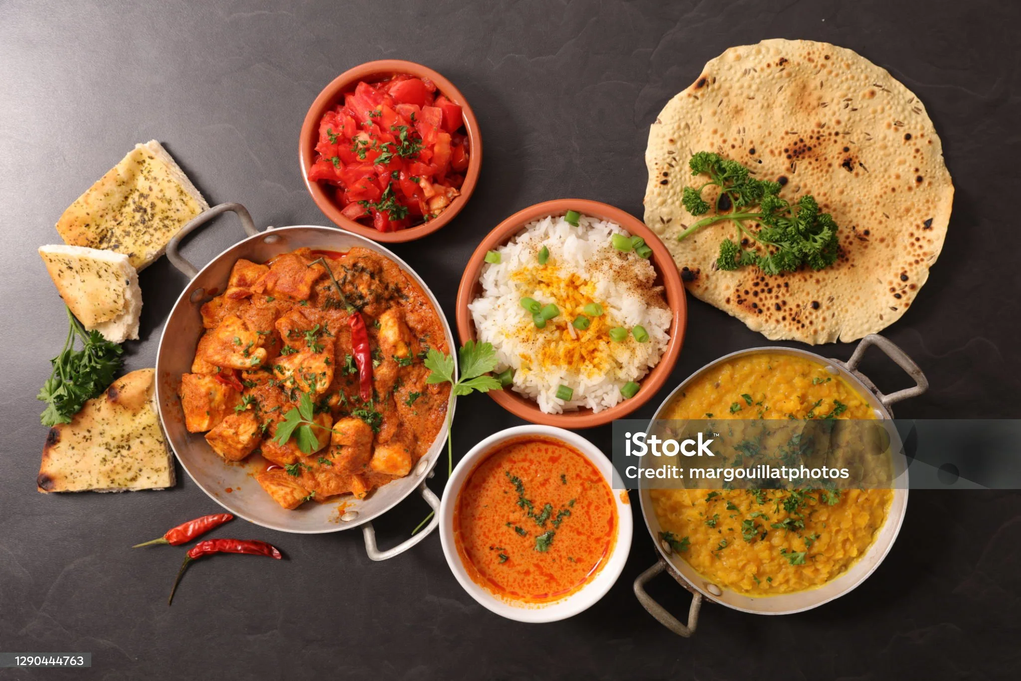 Indian thali with chicken curry, dal, rice, and naan bread