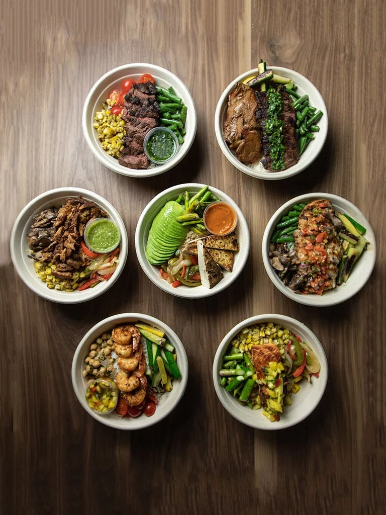 Assorted Mexican-style protein bowls with fresh vegetables and salsas