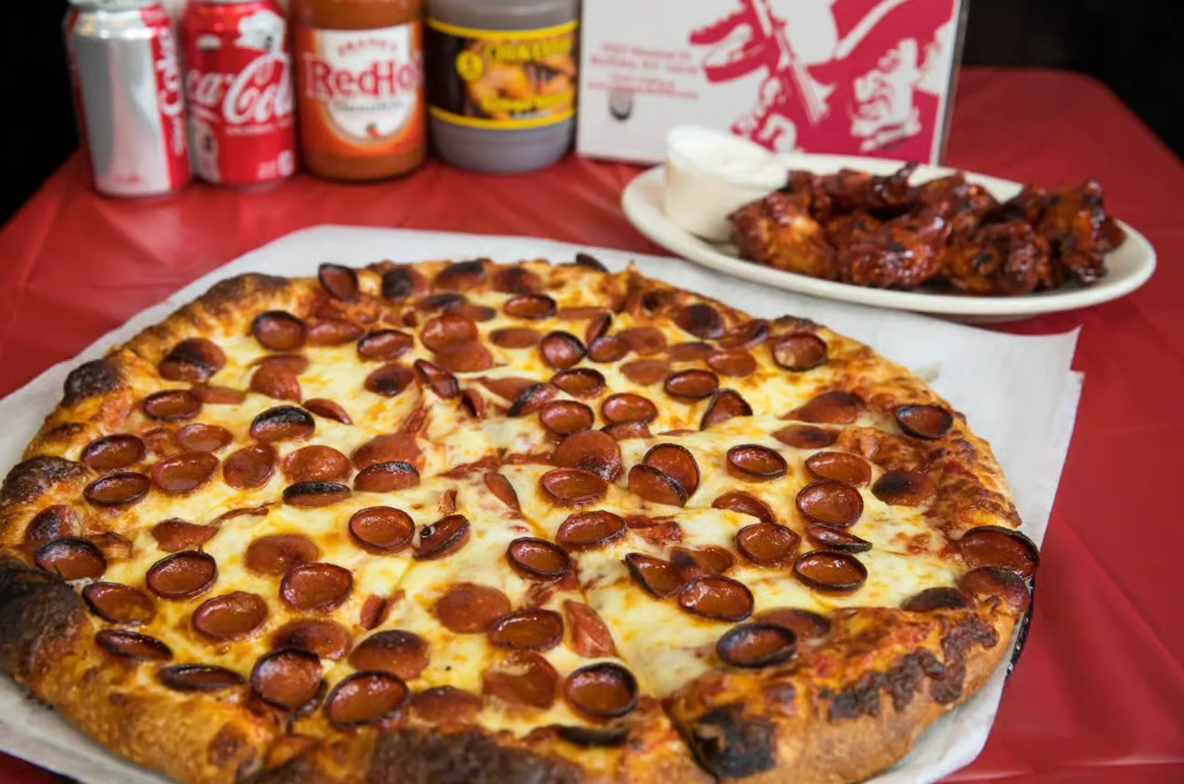 Pepperoni pizza served with buffalo wings
