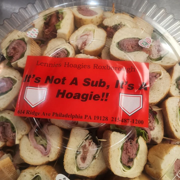 A platter of hoagies featuring various fillings, with a bold label proclaiming 'It's Not A Sub, It's A Hoagie!!'. The hoagies are cut into bite-sized pieces and arranged neatly.