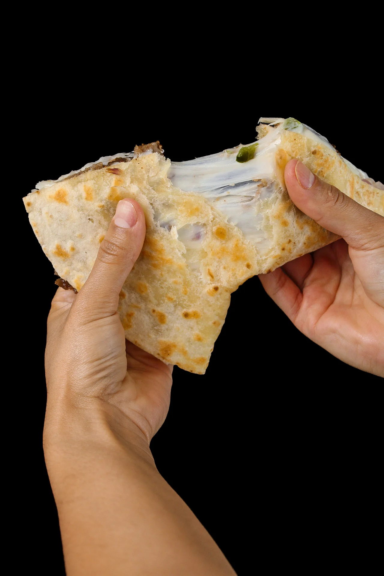 A person pulling apart a gyro